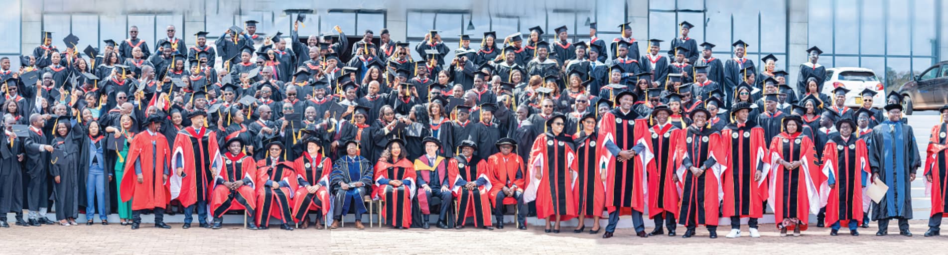 Graduates and faculty members with graduation gowns and caps