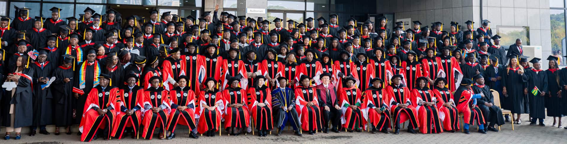 Graduates and faculty members with graduation gowns and caps