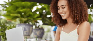 Smiling woman with laptop outdoors