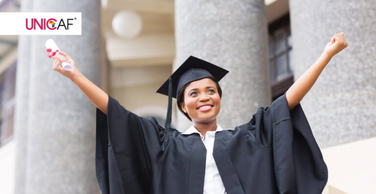 Graduate smiling and holding diploma in celebration.