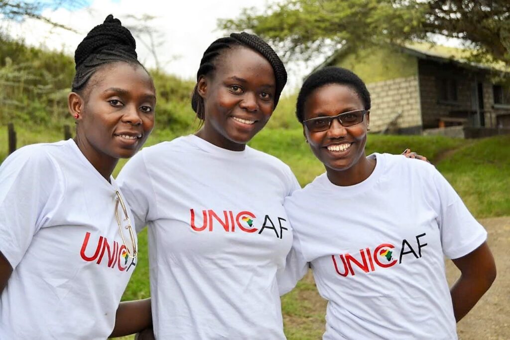 Smiling students wearing t-shirts with Unicaf logo.